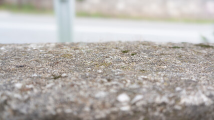 Close-up rough concrete table-top out door in bokeh. Stone or concrete, shot with shallow depth of field. Natural texture outdoor for backgrounds or design use for copy space.