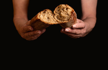 Woman hands breaking freshly baked bread, closeup. Fresh loaf of bread in woman hands. Male hands breaking freshly baked bread, closeup. Baker females hands breaks in half fresh baked bread loaf