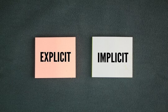 Colored paper with the words explicit and implicit. motivational words positive and negative