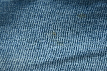torn light grey denim surface, denim fringe , hole macro texture of blue denim, torn blue denim texture as background photo close up from above	
