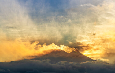 mysterious mountain in sunset orange and blue clouds in evening light with slopes with snow and...