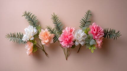 Obraz premium Lush faux flowers and greenery are arranged in a flat lay style against a soft pastel background, creating a decorative and inviting atmosphere with empty space