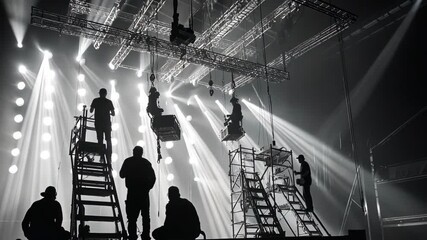 Backstage: stage crew working on lighting rig for a concert or event.