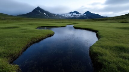 Serene mountain valley reflecting in tranquil pool. Lush green meadow surrounds still water, mirroring peaks in a soft light