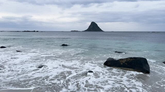 White sand beach with turquoise ocean water and a mountain in Bleik beach, Lofoten islands, Norway