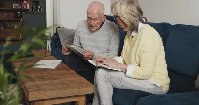 Senior couple reading paperwork, pension report and finance documents in home for life insurance policy. Elderly man, woman and discussion of retirement budget, financial will and investment planning