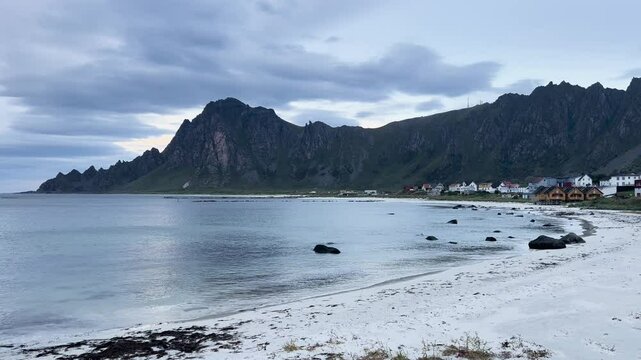 White sand beach with turquoise ocean water and a mountain in Bleik beach, Lofoten islands, Norway