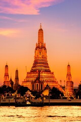 Obraz premium Majestic sunset over Wat Arun illuminating the Chao Phraya River in Bangkok Thailand