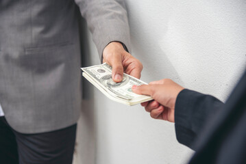 Close up hands giving money bribe payment. Hands holding dollar bill bribery financial economy business people. Business people corrupt illegal settlements try to pay graft. Corruption bribe concept