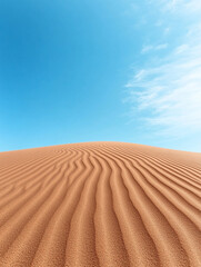 Fototapeta premium A vast desert with sweeping sand dunes and a bright, clear blue sky overhead, creating a striking and minimalistic landscape perfect for travel