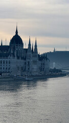 Gothic architecture of Budapest Parliament by the Danube River, misty dawn, travel destination,...