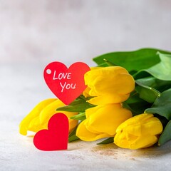 Fototapeta premium 鮮やかな黄色のチューリップがメインの花束に赤いハートタグがアクセントを加え、‘Love You’のメッセージが心温まるバレンタインギフト