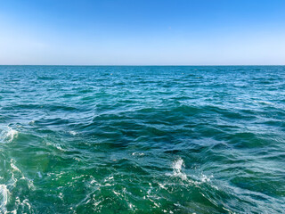 bright turquoise sea with gentle waves under clear blue sky background with copy space. summer seascape with refreshing and vibrant