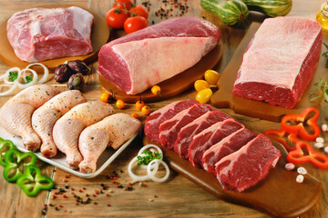 Mesa com cortes de carne bovina e coxa de frango cru