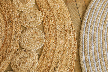 Crafted natural fiber mats displayed on a wooden surface with intricate designs