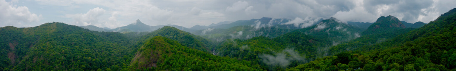 Cloudy mountains of the Western Ghats stand tall, their peaks wrapped in mist. Forests breathe with monsoon life, as clouds drift through valleys in silent grace.