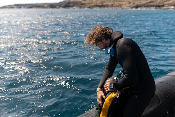 Obraz premium Diver checking scuba equipment on boat before diving in the sea