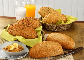 mesa de café da manhã com suco, leite, cereais e pães variados