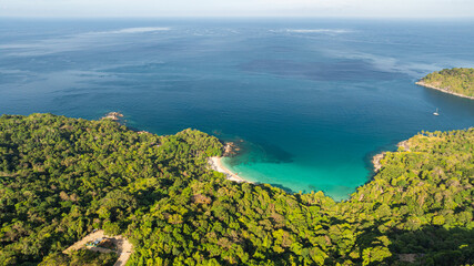 Forest shadows cast over the beach in the morning. A small white beach hidden in the jungle and...