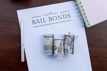 A formal bail bonds document lies on the desk beside a stack of cash, representing the financial...
