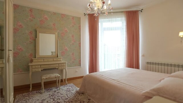 A cozy bedroom featuring a bed, a dresser, a mirror, and a beautiful chandelier