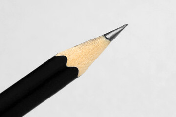 One sharp graphite pencil on light background, closeup