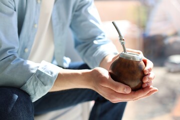 Man with traditional yerba mate tea at home, closeup
