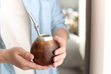 Man with traditional yerba mate tea at home, closeup