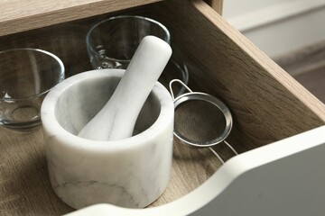 Marble mortar and pestle in drawer indoors, closeup