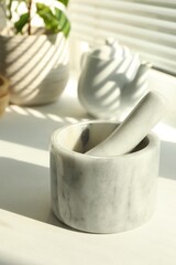Marble mortar and pestle on windowsill indoors, closeup