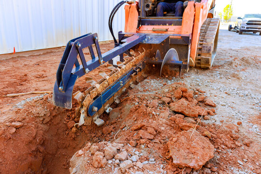 Trencher track uploader with prepares trench on construction site operation.