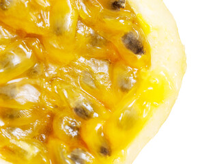A close up of a yellow fruit with black seeds