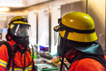 A firefighters in full protective gear, mask, and oxygen tank stands ready during a fire drill on...