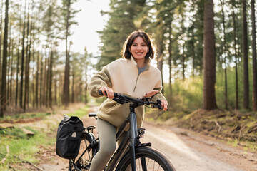 Fototapeta premium Fresh air, warm light and wild freedom, a modern traveler is cycling into her dream holiday getaway