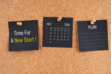 November 2026 calendar with Time for a new start and Plan text on black adhesive notes with wooden.