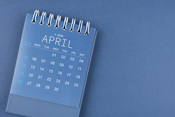 April 2026 calendar on blue background. Desk calendar for planning and organizing.
