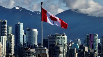 A View of the Canadian Flag Waving Against a Backdrop of Mountains and Modern High-rises, as Seen From South Granville in Downtown Vancouver, Canada - Zoom In Shot