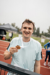 Amateur runner receives medal after running competition. Running competition at stadium