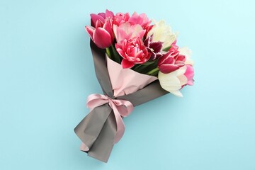Bouquet of beautiful tulips on light blue background, top view