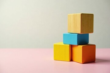 Obraz premium Colorful Wooden Blocks Arranged in a Balanced Stack on a Pink Surface