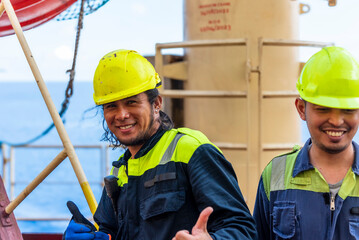 Portrait of a young Filipino marine engineer aboard a large container ship, gazing ahead with a...