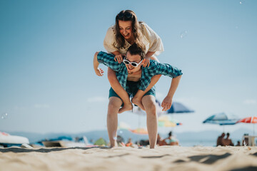 Two friends sharing a cheerful moment enjoying a fun piggyback ride on a sunny summer beach,...