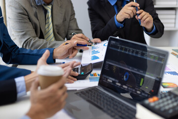 Businessman analyzing financial chart and report using laptop computer. Business people working...