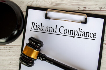 Top view of Risk and Compliance text on clipboard with gavel on top. Code of Conduct concept.