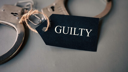 Handcuffs with a tag written 'Guilty'