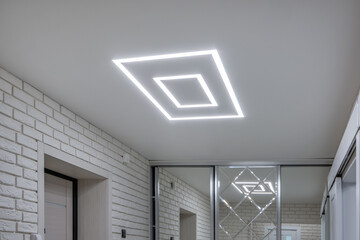 suspended ceiling with halogen spots lamps in form of squares and rectangles and drywall...