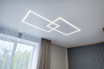 suspended ceiling with halogen spots lamps in form of squares and rectangles and drywall...