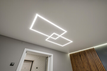 suspended ceiling with halogen spots lamps in form of squares and rectangles and drywall...