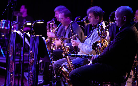 Big Band Saxophones. A view across the sax section in a big band performing together live on stage.