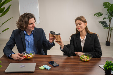 Colleagues Toasting Coffee Cups During Office Lunch Meeting